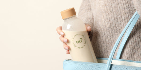 Frau packt Wasserflasche in ihre Handtasche