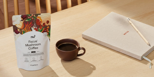 nu3 Focus Mushroom Coffee mit Tasse und Notizblock auf dem Tisch