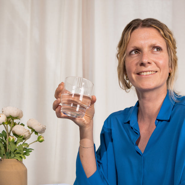 Frau, die ein Glas hält