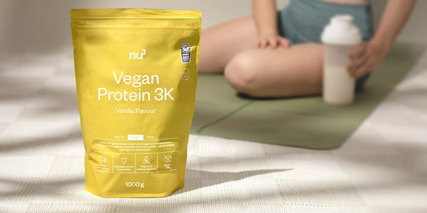 nu3 Vegan Protein 3K Vanille vor Sportlerin auf Fitnessmatte
